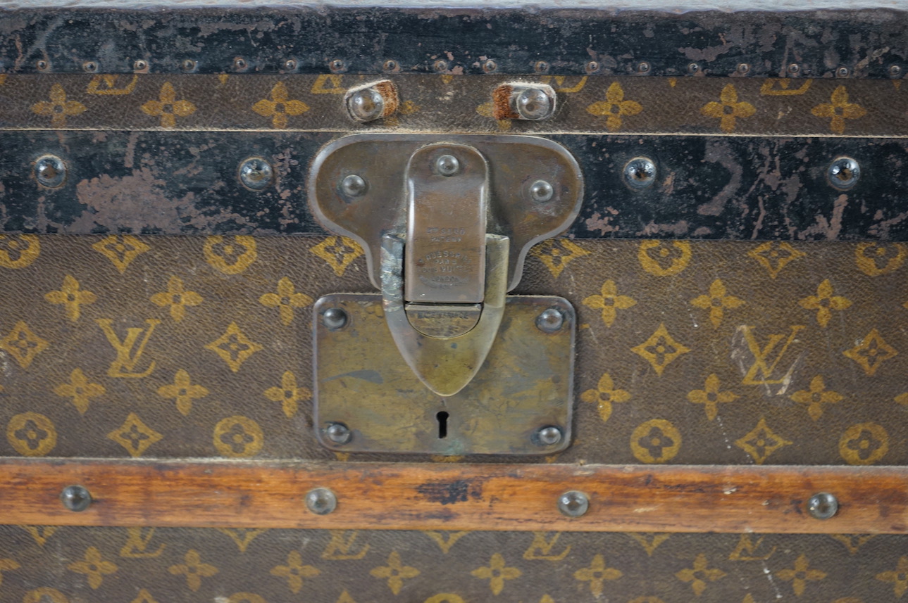 A vintage Louis Vuitton trunk, with wooden slats and black painted steel bound LV canvas, label for Paris, Nice, Lille and London, and numbered stamp 212361, with two internal canvas trays, 100cm wide, 54cm deep, 58cm hi